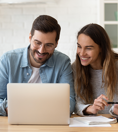 Therapist and client, both smiling and looking at a computer screen during a therapy payment session.